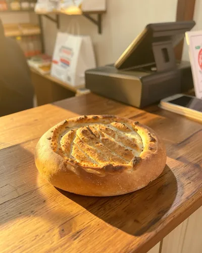Bakery, after: the same bread on a wooden counter in morning light